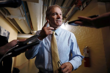 Photo, reporters' hands stretching in from all sides of the frame holding phones and recording devices, reaching towards House Judiciary Committee Chairman Jim Jordan, pictured center, in a passageway within the U.S. Capitol