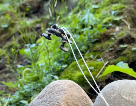 Four legged miniature machine hovering above 2 stones in green landscape