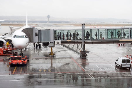 Passengers boarding an airplane through a boarding bridge