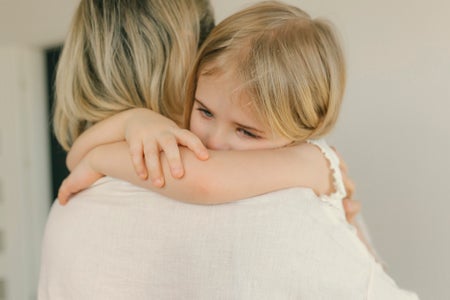 Sad daughter embracing mother at home