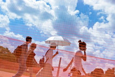 Several people walking in Washington with umbrella and white clouds and red grid effect covering the image.