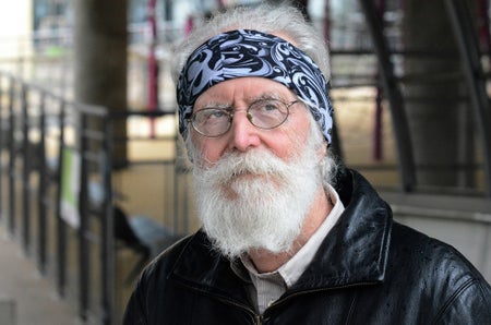 A portrait of a bearded man wearing glasses and a bandana.